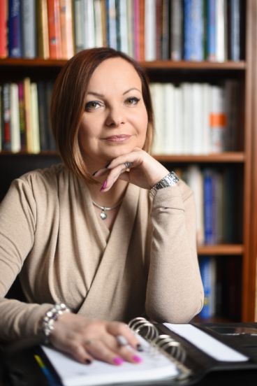Benedek Szilvia portréja könyvespolc előtt